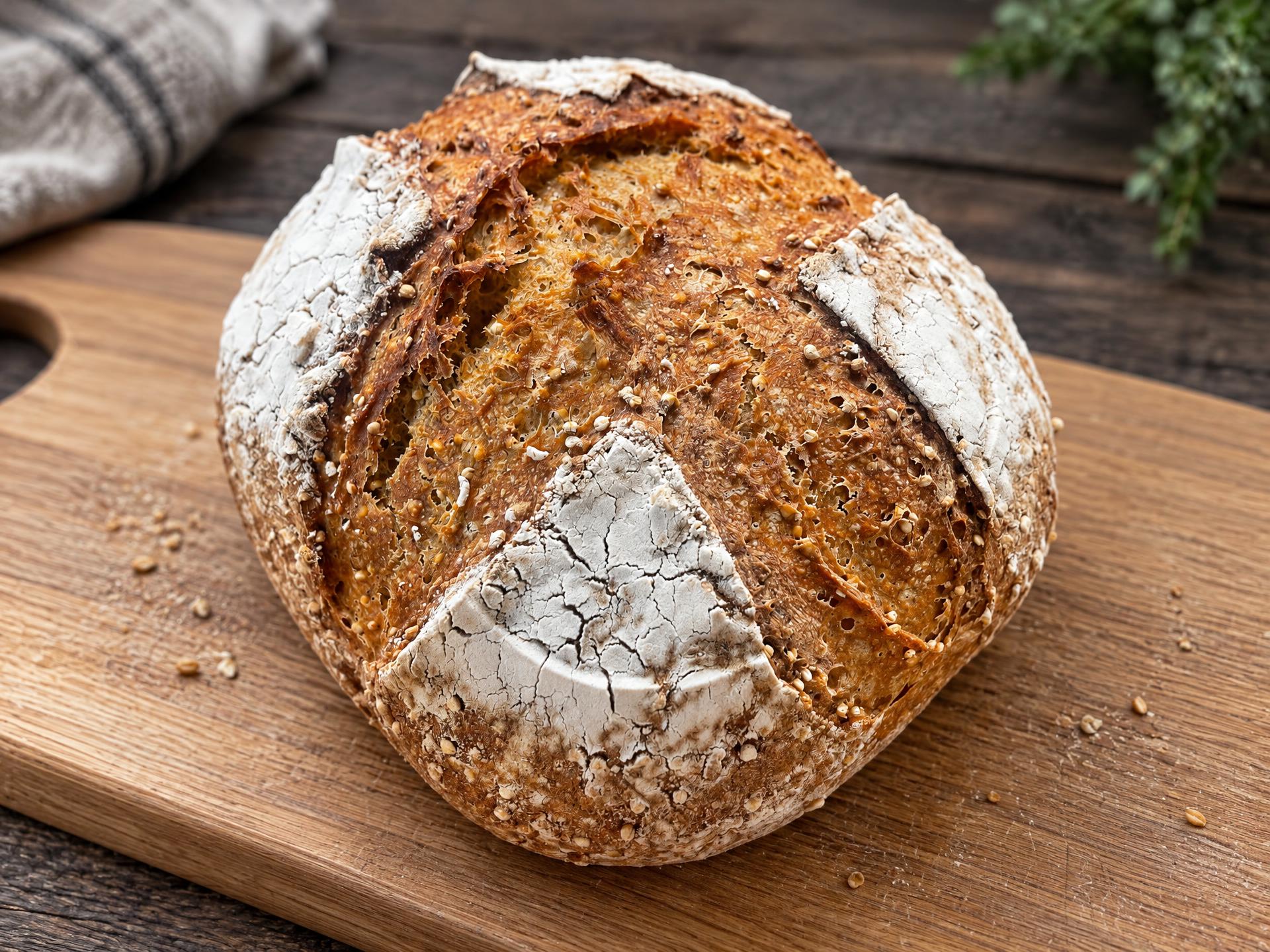 Large seed-crusted sourdough boule, golden amber crust